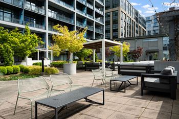 A patio with a table, chairs and a bench.